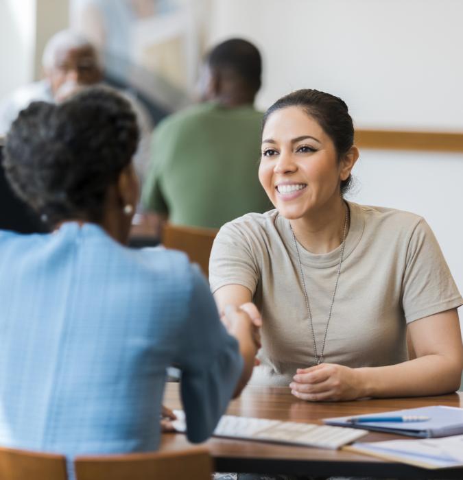 Veteran shaking hands with financial representative at bank